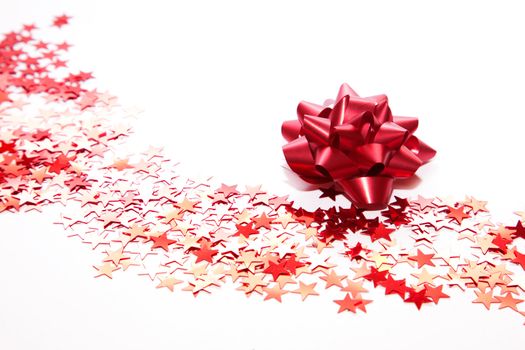 Christmas decoration. Red ribbon and little stars on white