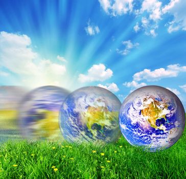 Earth globe rolling on green grass conceptual
