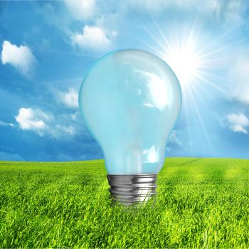 Green energy concept. Light bulb on nature background