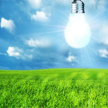 Green energy concept. Light bulb on nature background