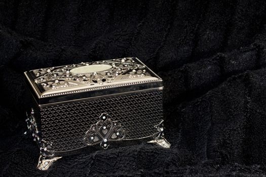 A silver box on a black fur