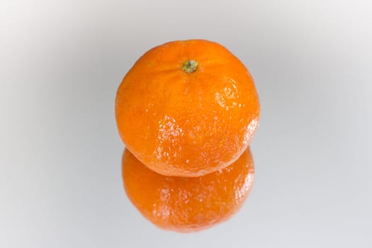 An orange reflecting on a mirror