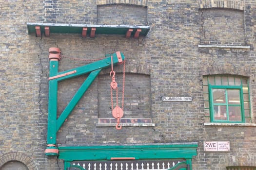Old wooden goods lift winch on a brick wall in London
