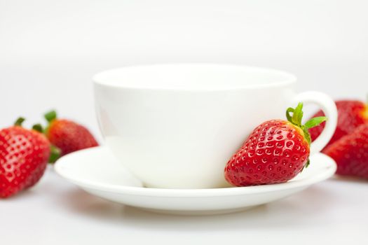 white cup and strawberries isolated on white