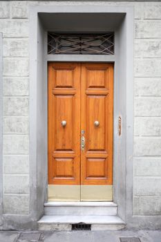 Fragment of old stone building with nice wooden door