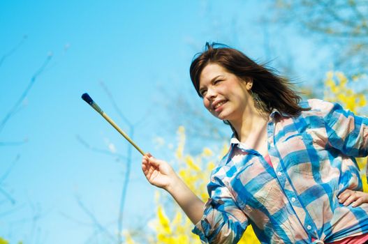 Painting the world. Smiling girl with a paintbrush