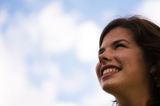 Happy girl looking on puffy clouds. Conceptual.