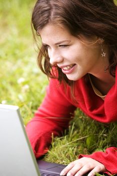 A beutiful student girl working on her laptop outdoor at sunny day