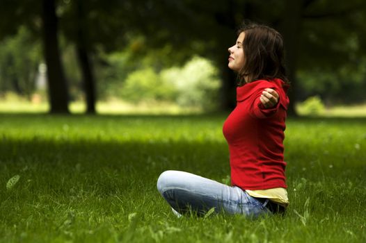 A beautiful young woman doing yoga in the park