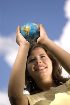 Pretty teen girl watching Earth globe. Conceptual image