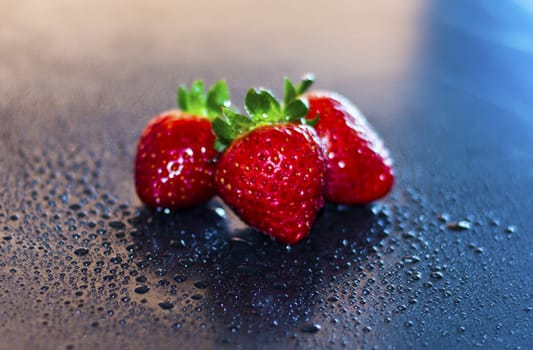 red, fresh strawberries in drops of water