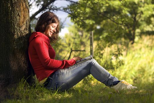 A beutiful student girl working on her laptop outdoor at sunny day