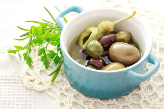 Olives in little pot on white table cloth