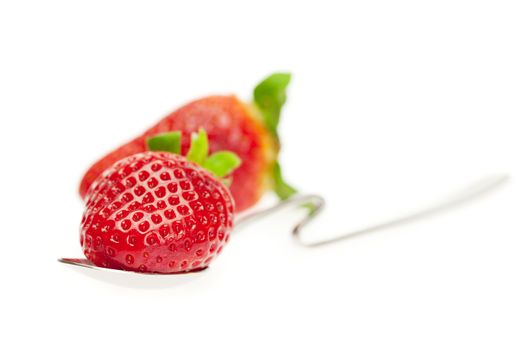 juicy strawberries on spoon isolated on white