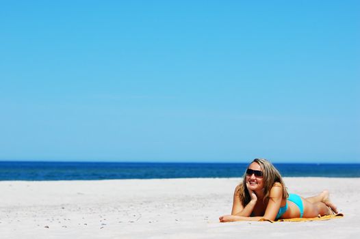 Beautiful woman relaxing on the beach. Lots of useful copyspace