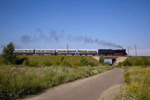 Old retro steam train passing through polish countryside
