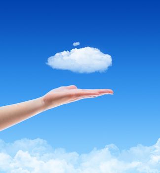 Woman hand offer the cloud against blue sky with clouds. Concept image on cloud computing and ecology theme with copy space.