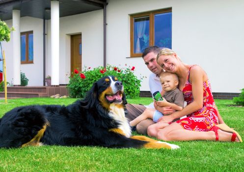 Happy family in front of their house