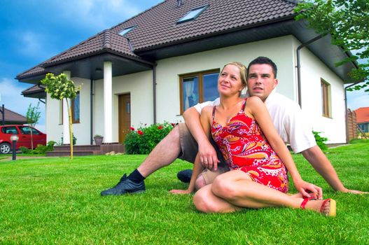 Happy couple in front of their ideal house