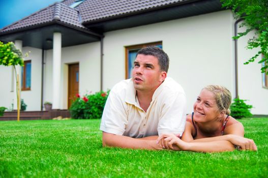 Happy couple in front of their ideal house