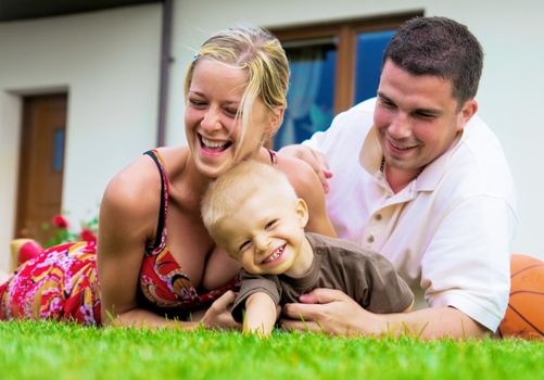 Happy family having fun in front of their house