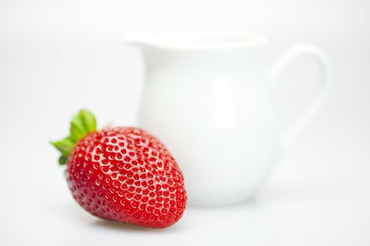 strawberries and milk jug isolated on white