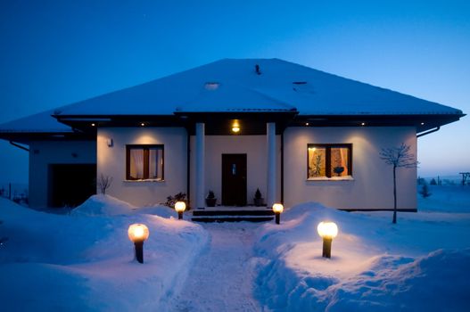 House in winter. Lots of snow, evening mood