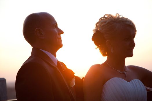 Happy bride and groom together outdoors at sunset