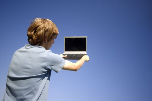 Boy and laptop on sky background