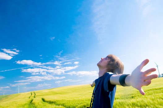 Happy man with arms up on summer lanscape