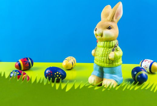 Easter bunny and colored eggs on blue background