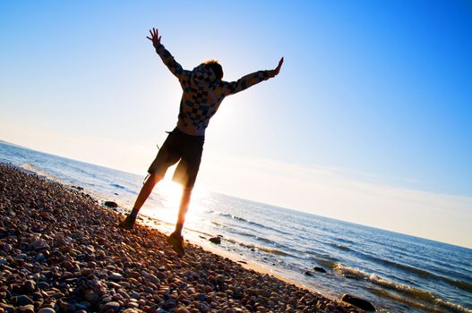 Happy boy jumping for joy at the beach