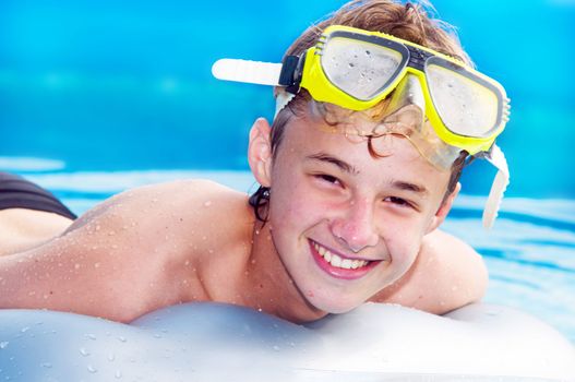 Happy smiling boy swimming in a pool