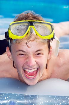 Happy playful boy swimming in a pool