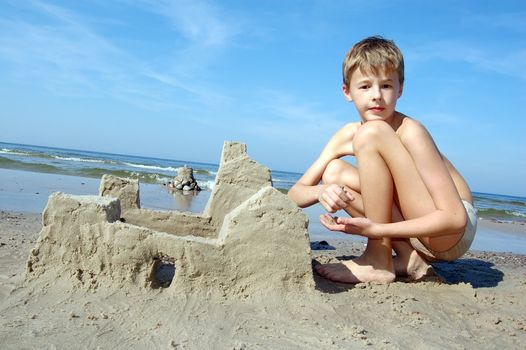 Boy playing on the beach in summertime