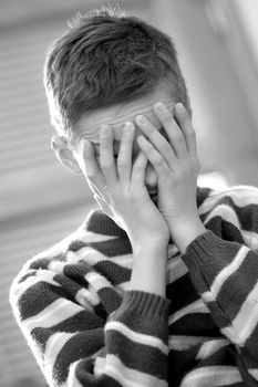 Portrait of young boy sitting sadly