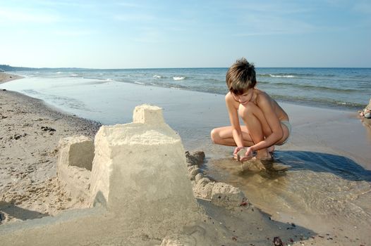Boy playing on the beach in summertime