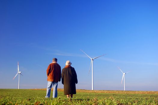 Seniors' couple looking on wind turbines