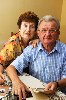 Senior couple looking at old photographs. Reminisce about the past