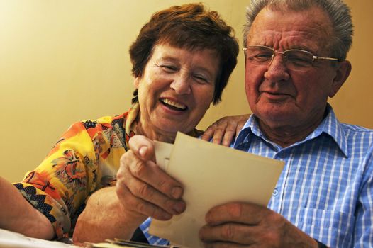 Senior couple looking at old photographs. Reminisce about the past