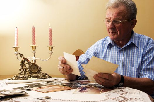 Senior man looking at old photographs. Reminisce about the past