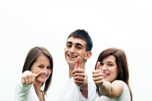 Three young happy friends laughing and giving okey sing