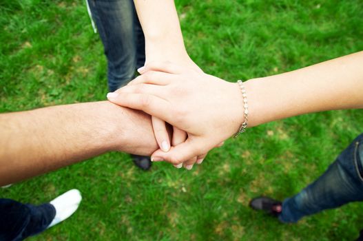 Group of friends joining hands. Unity, teamwork concept