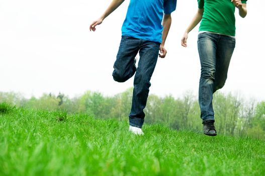 Carefree friends running together on green meadow