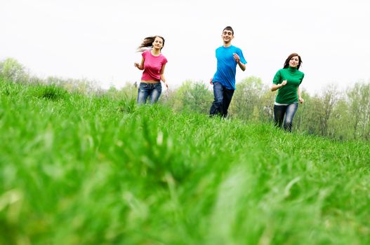 Three happy friends having fun on the spring meadow