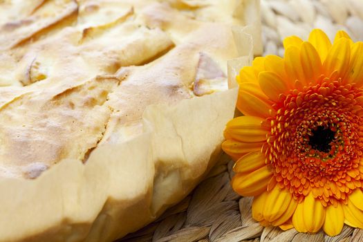 apple pie and a flower on a wicker mat