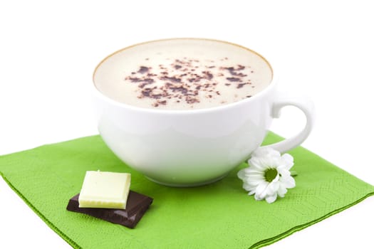 cup of cappuccino, chocolate and flower on a napkin