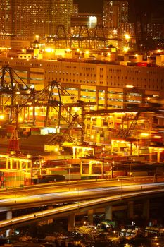 Port warehouse with cargoes and containers at night