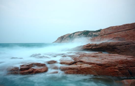 rocky sea coast and blurred water in shek o,hong kong 