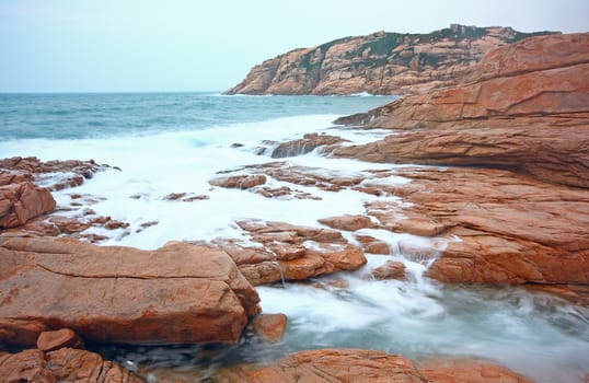rocky sea coast and blurred water in shek o,hong kong 